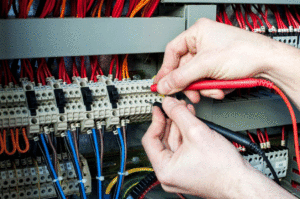 Person connecting red and black wires to a circuit board